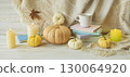 Cozy autumn still life with coffee, wool blanket, pumpkins, candles and books. Seasonal still life. 130064920