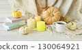 Cozy autumn still life with coffee, wool blanket, pumpkins, candles and books. Seasonal still life. 130064921