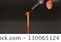 Lighting incense stick with small torch flame close up hand holding torch red incense dark background spiritual calm ritual meditation relaxation focus 130065124