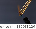 Burning incense stick smoke flame aromatic meditation relaxation spiritual dark background calming ritual. Burning incense sticks with visible flame and smoke create calming and spiritual 130065126