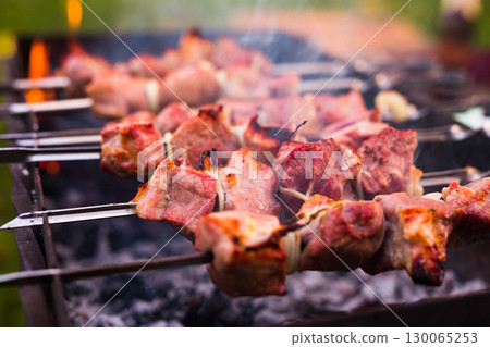 Juicy cuts of meat are grilled on grill. Outdoor recreation concept 130065253