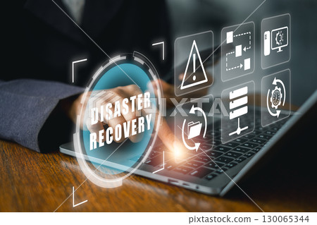 Futuristic digital interface illustrating disaster recovery with technology icons on a laptop screen. 130065344