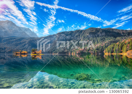 Stunning autumn landscape of Eibsee Lake in front of Zugspitze summit under sunlight. 130065392