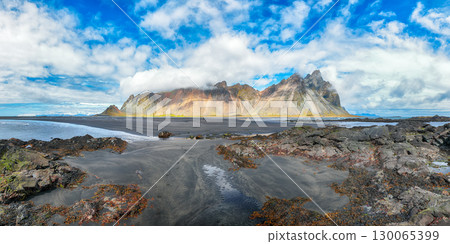 Amazing sunny day and dramatic black sand beach on Stokksnes cape in Iceland Amazing sunny day and dramatic black sand beach on Stokksnes cape in Iceland 130065399