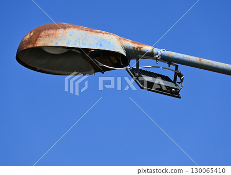 Old rusty street light against blue sky Old rusty street light against blue sky 130065410