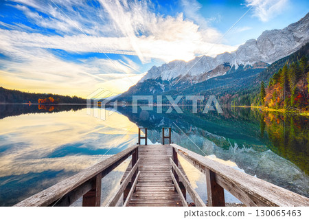 Stunning autumn landscape of Eibsee Lake in front of Zugspitze summit under sunlight. Stunning autumn landscape of Eibsee Lake in front of Zugspitze summit under sunlight. 130065463
