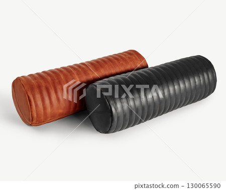 Two decorative leather bolster pillows resting on white background 130065590