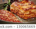Delicious lasagna bolognese with grated parmesan and arugula on rustic plate 130065669