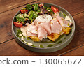 Potato pancakes with ham, poached egg and salad on wooden table 130065672
