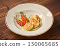 Delicious chicken cutlets with mashed potatoes and vegetable sauce lying on white plate on wooden table 130065685