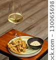 Crispy fried green beans appetizer with dipping sauce and white wine 130065698