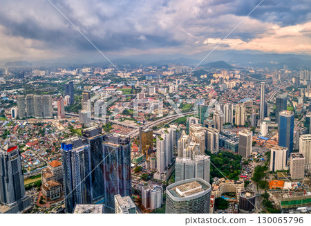 Panoramic aerial view, Kuala Lumpur, Malaysia, urban skyline, high-rise buildings, suburban areas, mountains in background, dense city architecture, transportation networks, dramatic sky at daytime Panoramic aerial view, Kuala Lumpur, Malaysia, urban skyline, high-rise buildings, suburban areas, mountains in background, dense city architecture, transportation networks, dramatic sky at daytime 130065796