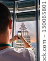 Nov 20, 2019 - Kuala Lumpur, Malaysia: Unrecognizable male adult tourist taking photo of Petronas tower with smartphone through window at colorful sunset.Observation deck visit, tourist attraction 130065801