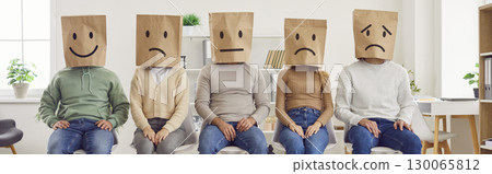 Faceless anonymous people sitting with paper bag on head with drawn smile and upset faces. 130065812