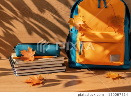 Fresh Start: New Backpack with School Supplies and Autumn Leaves 130067514