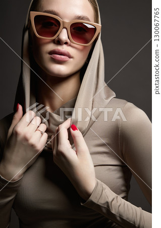 Beautiful young woman in sunglasses and hood Beautiful young woman in sunglasses and hood 130067765