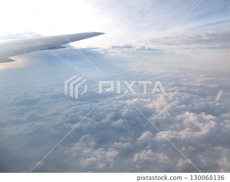 A spectacular view of blue skies and a sea of clouds from an airplane window 130068136