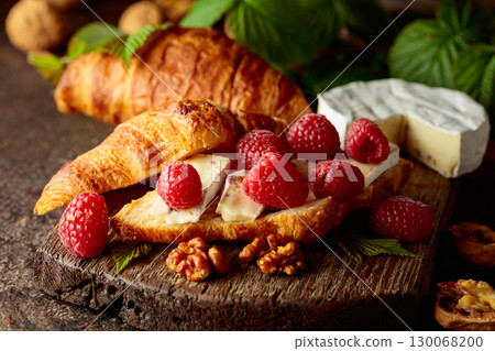 Croissant with camembert cheese, raspberries and walnuts. Croissant with camembert cheese, raspberries and walnuts. 130068200