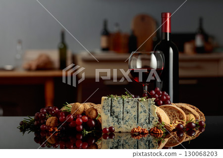 Gorgonzola cheese with ciabatta, walnuts, grapes, and red wine on a kitchen table. Gorgonzola cheese with ciabatta, walnuts, grapes, and red wine on a kitchen table. 130068203