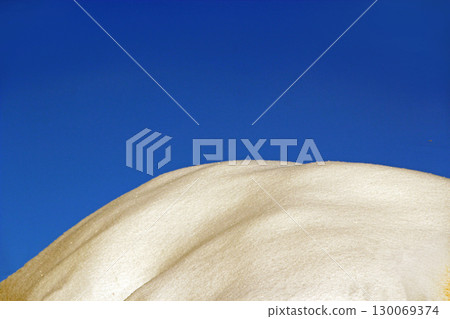 Snow covered mountain. Winter landscape. Snowy hill against blue sky. 130069374