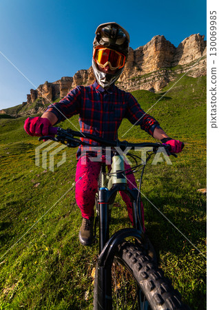 Sports. A cyclist stands alone in a field. A person riding a bicycle in a downhill style. 130069985