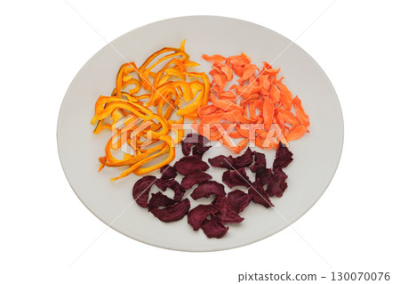 Adventure food. Nutritious snacks. Dried beetroot, sweet pepper and carrot on a ceramic plate isolated on a white background. Various dry of vegetables. 130070076