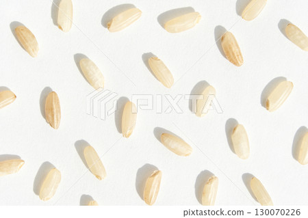 Close up of uncooked rice grains on white surface in patterned arrangement 130070226