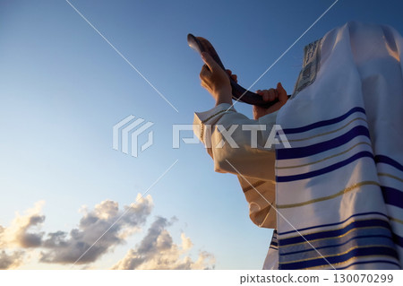 Jewish man blowing the Shofar horn of Rosh Hashanah - New Year. Shofar at Sunset Jewish man blowing the Shofar horn of Rosh Hashanah - New Year. Shofar at Sunset 130070299