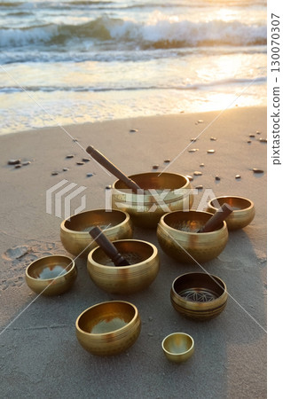 Tibetan Singing Bowls on Beach at sunrise. Tibetan Singing Bowls on Beach at sunrise. 130070307