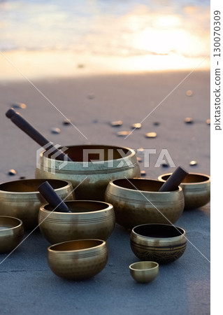 Singing Bowls on Beach at sunrise. Singing Bowls on Beach at sunrise. 130070309