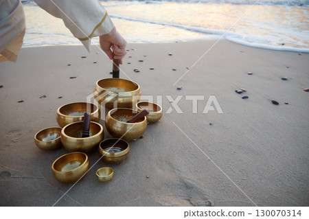 Singing Bowls on Beach at sunrise. 130070314