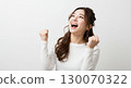 A young Japanese woman looking up diagonally and pumping her fist, with an expression full of joy and a sense of accomplishment - pass, delight, happy 130070322
