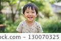 A lively boy laughing innocently in a green park 130070325