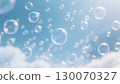 A blue sky with white clouds and countless soap bubbles shining in rainbow colors in the sunlight. 130070327