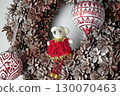 Christmas wreath made of pine cones covered with frost and glass balls with a teddy bear 130070463