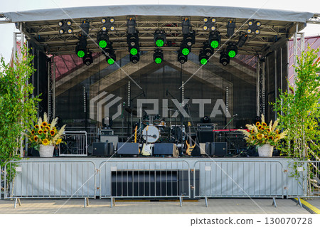 Outdoor concert stage with instruments, lights, and decorations prepared for live performance 130070728