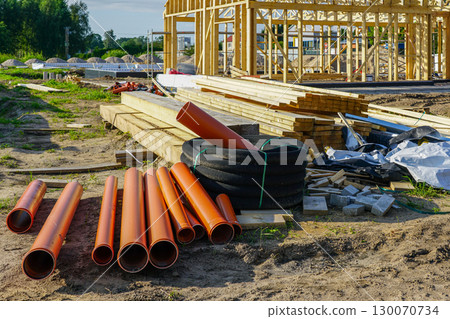 Construction materials with pipes, wooden beams, and supplies at building site Construction materials with pipes, wooden beams, and supplies at building site 130070734