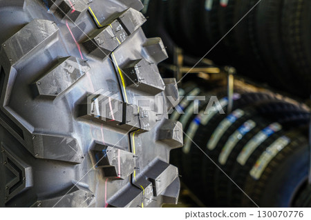 Close-up of rugged ATV off-road tire tread pattern displayed in a tire shop 130070776