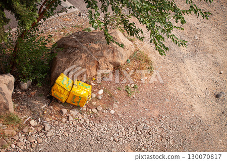 08/25/2025 Georgia, Tbilisi, Delivery packages, Glovo company, left on stony ground, near bushes, outdoors, no people 08/25/2025 Georgia, Tbilisi, Delivery packages, Glovo company, left on stony ground, near bushes, outdoors, no people 130070817