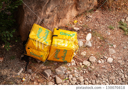 08/25/2025 Georgia, Tbilisi, Delivery packages, Glovo company, left on stony ground, near bushes, outdoors, no people 08/25/2025 Georgia, Tbilisi, Delivery packages, Glovo company, left on stony ground, near bushes, outdoors, no people 130070818