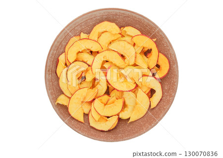Dried apples in a plate isolated on a white background. Various dry slices of fruits. Homemade preparation of snack. Top view. 130070836