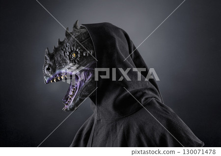 Portrait of a dragon with hooded cape over dark foggy background 130071478