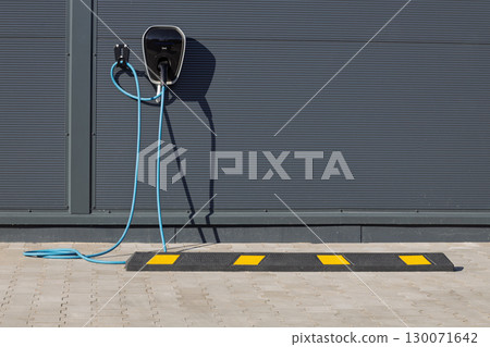 Modern electric vehicle charger on building wall Modern electric vehicle charger on building wall 130071642