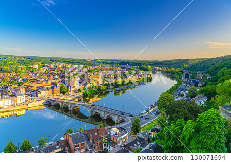 Namur cityscape with Meuse river embankment and Pont de Jambes arch stone bridge, aerial panoramic view of Namur city, skyline horizon with green forests trees on hills, Wallonia Region, Belgium Namur cityscape with Meuse river embankment and Pont de Jambes arch stone bridge, aerial panoramic view of Namur city, skyline horizon with green forests trees on hills, Wallonia Region, Belgium 130071694