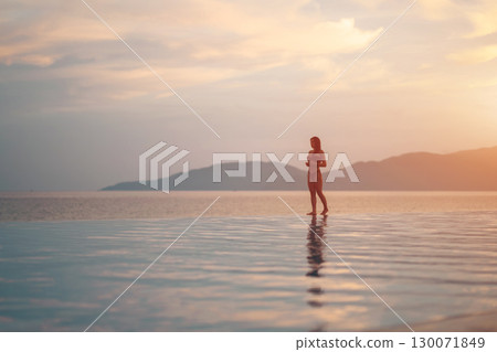 beautiful girl walking by pool flowing into sea at sunrise, serene elegance and morning peace, stunning female strolling near ocean edge at sunset or sunrise beautiful girl walking by pool flowing into sea at sunrise, serene elegance and morning peace, stunning female strolling near ocean edge at sunset or sunrise 130071849