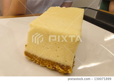 Delicious creamy cheesecake slice served on a white plate Delicious creamy cheesecake slice served on a white plate 130071899