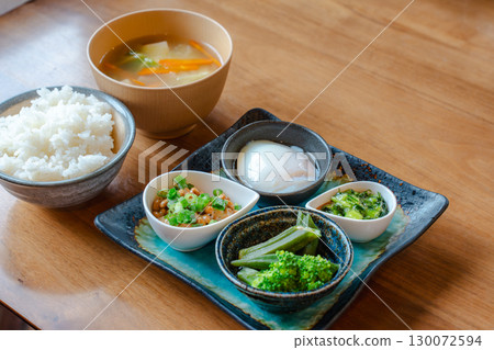 A Japanese-style breakfast set featuring rice, miso soup, natto, a soft-boiled egg, and a small bowl of vegetables A Japanese-style breakfast set featuring rice, miso soup, natto, a soft-boiled egg, and a small bowl of vegetables 130072594