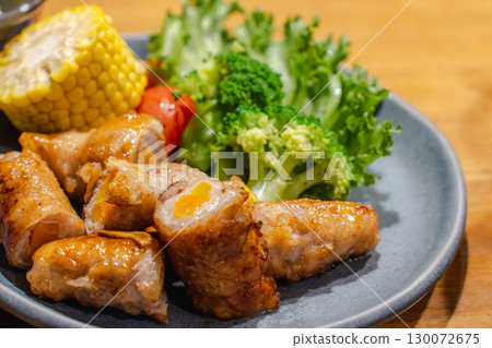 晚餐是蔬菜捲豬肉,配菜是玉米、蔬菜和黃瓜 晚餐是蔬菜捲豬肉,配菜是玉米、蔬菜和黃瓜 130072675