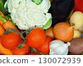 Closeup of assorted fresh vegetables including tomatoes, cauliflower, onions, garlic, carrots, eggplant and potatoes. 130072939