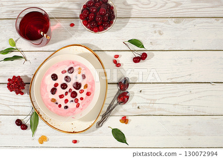Healthy breakfast with ingredients. Cherry yogurt with pomegranate, cherry, raisin and juice on wooden table, fruit salad, detox diet and natural nutrition concept, Healthy lifestyle advertising, 130072994